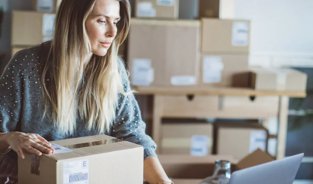 Woman on Computer with Boxes in background