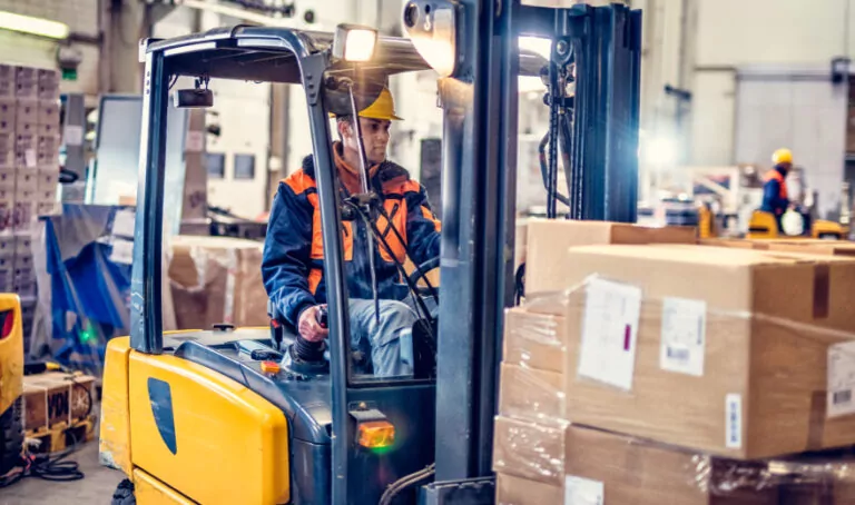 Worker moving boxes in warehouse