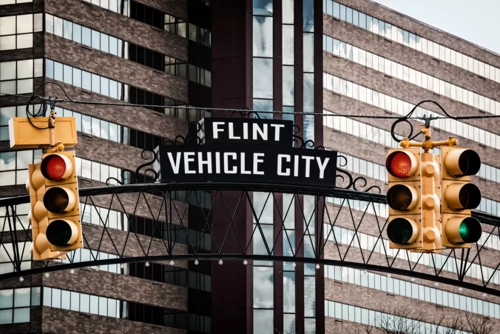 A street sign with a vehicle city sign above it, indicating the direction and location of the city.